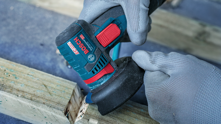 Object #200609219: 2840086_app_web_10 Person wearing safety equipment uses an angle grinder to sand a wooden surface.
