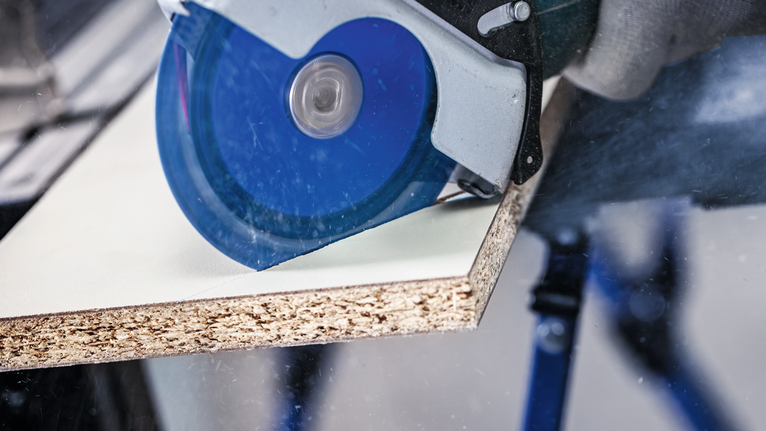 EXPERT Multi Material Carbide Cutting Disc, 125 x 22.23 mm, X-Lock Person wearing safety equipment cuts a wood board with a circular saw.