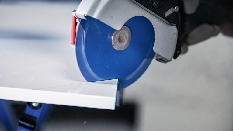 EXPERT Multi Material Carbide Cutting Disc, 125 x 22.23 mm, X-Lock Circular saw cutting a white tile sheet.