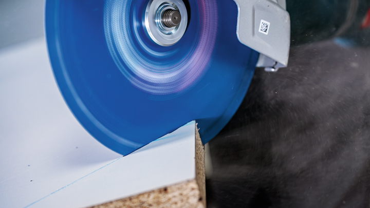 Object #200609266: 3065325_app_web_06 Circular saw blade cutting through a laminated wooden board.