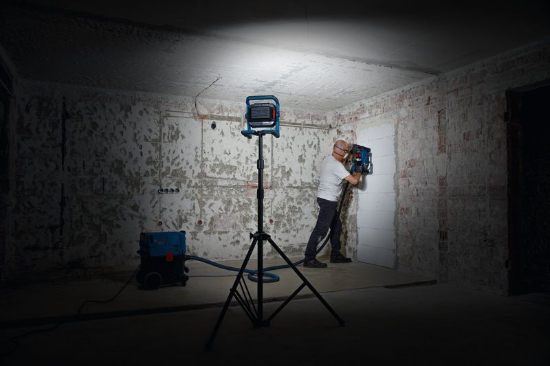 GLT 300-40 A person wearing safety equipment operates a wall drilling tool under work light.