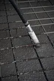 Concrete vibrator consolidating freshly poured concrete over a steel reinforcement grid.