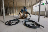 Construction site with two concrete vibrators and a backpack power supply on a pallet.
