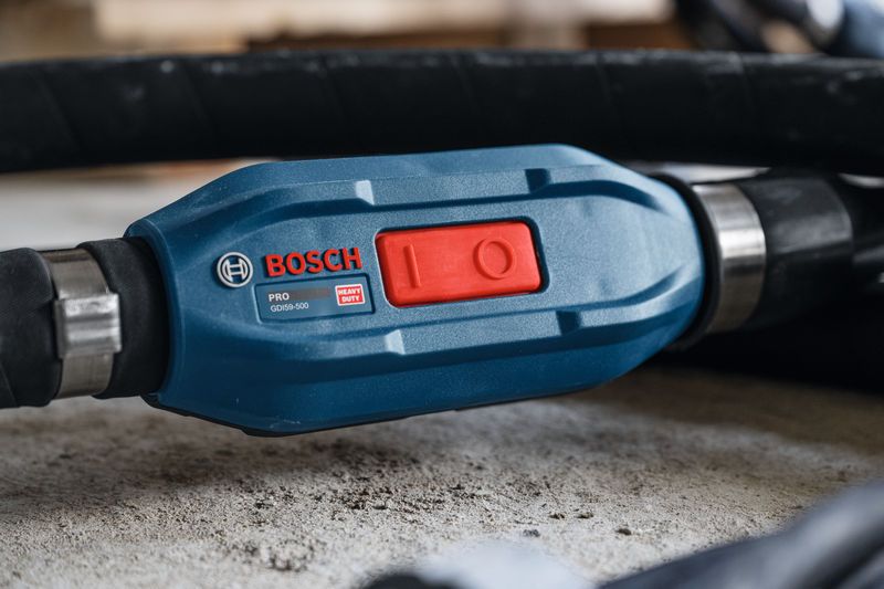 Close-up of a blue power tool switch marked GDI59-500 resting on a concrete surface.
