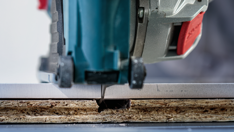 Jigsaw cutting a straight line through a laminate board.