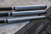 Three concrete vibrators rest on a construction surface.