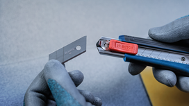 Person wearing safety equipment replaces a utility knife blade.