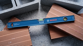 Blue spirit level rests on stacked bricks and concrete blocks.
