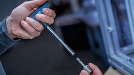 Person connects a socket to a magnetic nutsetter near a workbench.