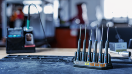 Precision screwdrivers neatly arranged in a stand on a workbench.