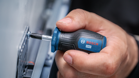 Person uses a screwdriver to tighten a screw in a metal bracket.