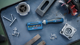 Screwdriver set and assorted metal parts arranged on a workbench.
