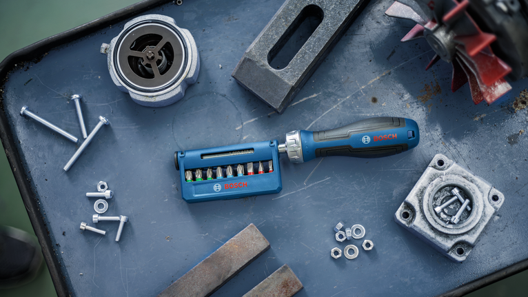 Screwdriver set and assorted metal parts arranged on a workbench.