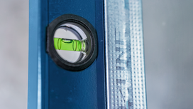 Spirit level bubble centered on a blue metal ruler.