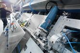 Straight grinder set up on an industrial metal machine with a person in the background.