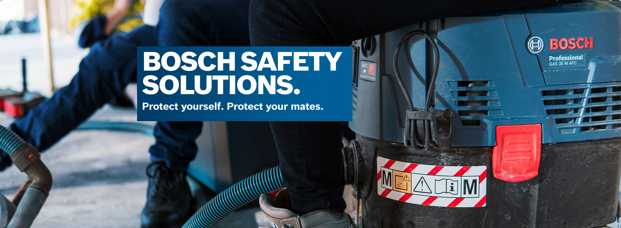 A Bosch Professional vacuum cleaner on a worksite, with a blue hose attached.