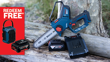 A Bosch Professional battery chainsaw rests on a log, with two batteries and a charger nearby. A red promotion banner is visible.