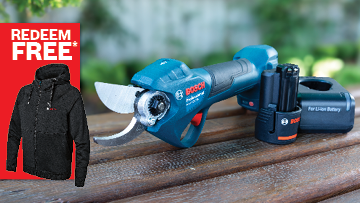A blue Bosch Professional cordless pruning shears is placed on a wooden surface, with a battery pack nearby.