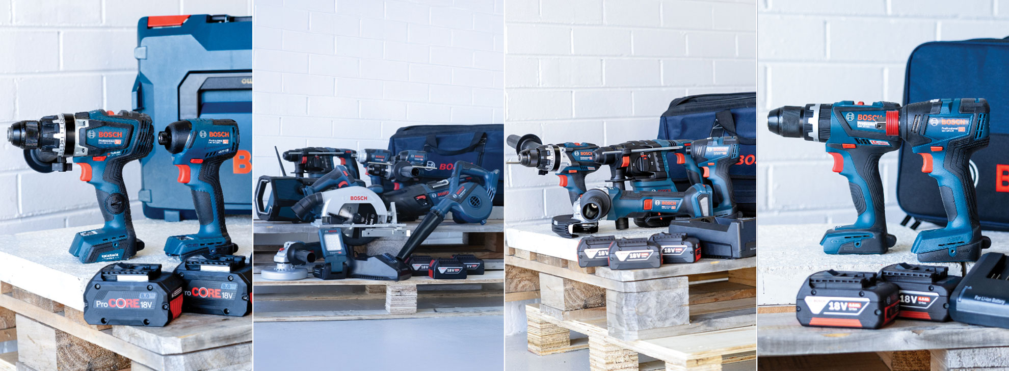 A collection of Bosch Professional power tools displayed on wooden pallets, featuring drills and a saw in blue and black with red accents, along with batteries and a carrying case, set against a white wall.