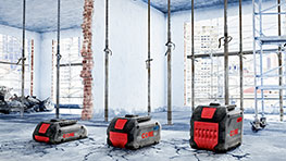 Three Bosch Professional tools with red accents on a construction site floor.